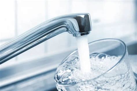 Imagen de un grifo moderno dispensando agua clara en una cocina luminosa
