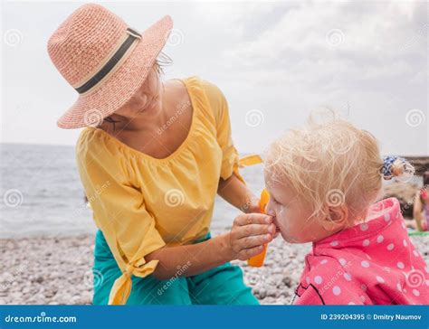 Bebé aplicando protector solar en la playa