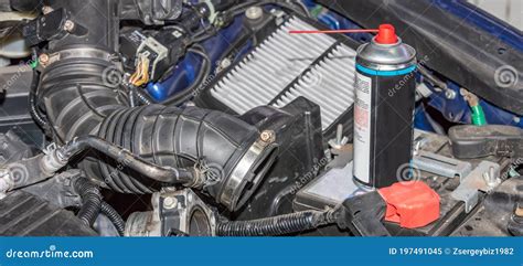 Mecánico inspeccionando un tubo de admisión de aire automotriz en busca de grietas.