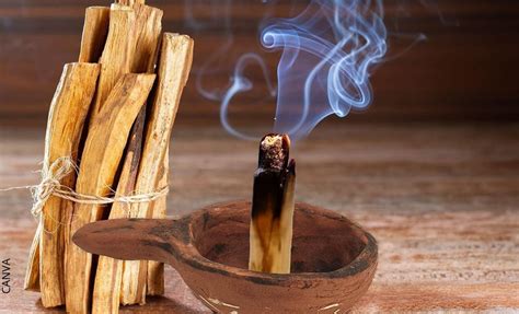 Manos sosteniendo un palo de Palo Santo encendido
