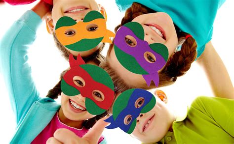 Niños jugando con capas y máscaras de Tortugas Ninja.