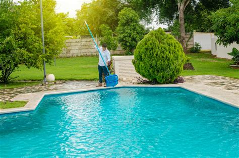 Persona limpiando una piscina con una red