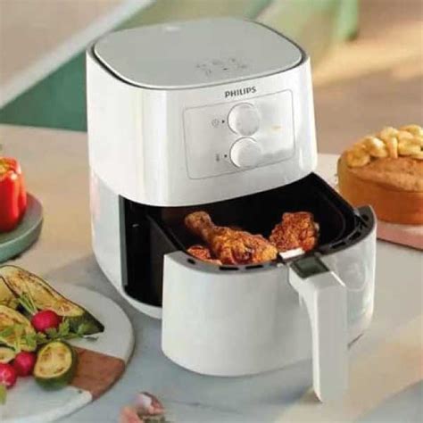 Persona lavando la cesta de una freidora de aire con una esponja