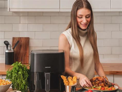 Persona limpiando una freidora de aire con productos naturales