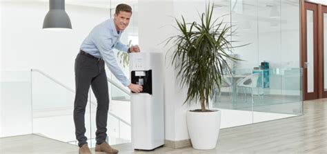 Asistentes en un evento recibiendo agua de un dispensador portátil