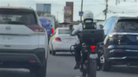 Motocicleta filtrando entre carriles de tráfico detenido