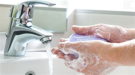 Persona lavándose las manos antes de ponerse una mascarilla