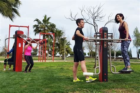 Personas haciendo ejercicio en un parque con equipamiento de gimnasio al aire libre