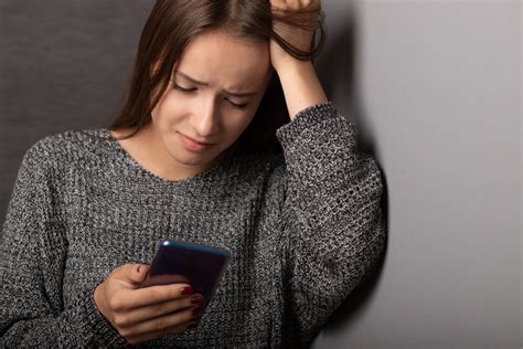 Persona mirando su teléfono con expresión de duda