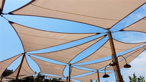 Diagrama mostrando la fijación de un toldo vela a un poste anclado en el suelo y a una pared