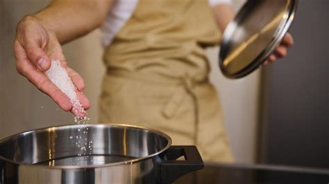 Imagen de una persona añadiendo sal a una piscina