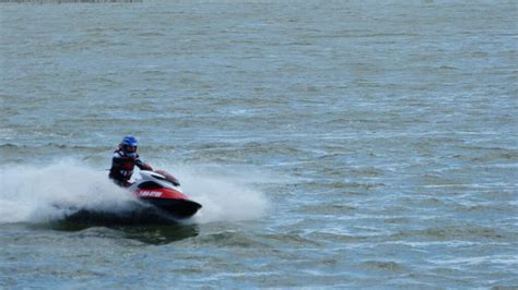 Persona limpiando una moto de agua en un muelle