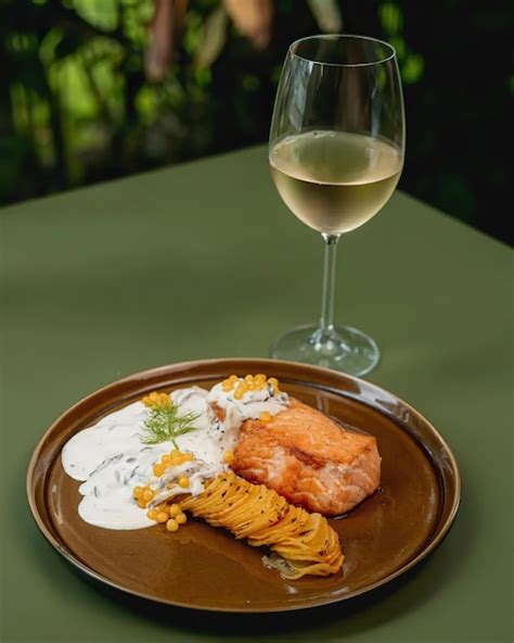 Copa de vino blanco canario junto a un plato de burgados