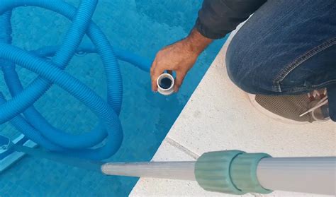 Persona enjuagando bolas de filtro de piscina con una manguera