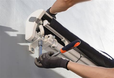 Persona aplicando silicona líquida en un toldo