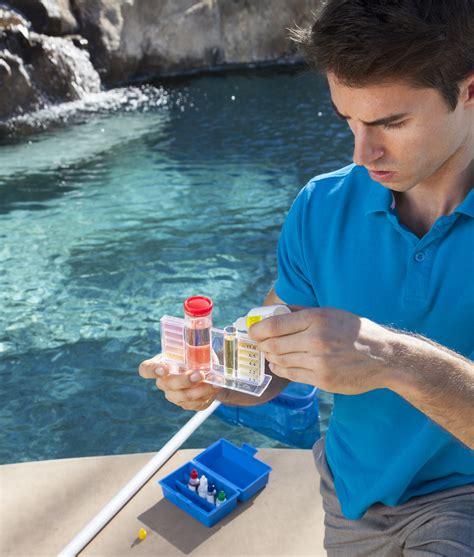 Hombre analizando el agua de una piscina con un kit de análisis