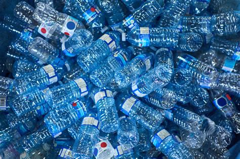 botellas de plástico apiladas junto a un grifo