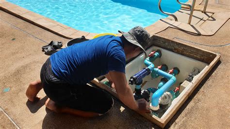 Persona instalando una bomba de piscina en el borde.