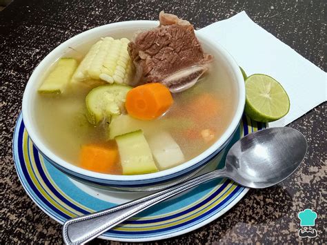 Ilustración de un tazón humeante de caldo de verduras con hierbas frescas