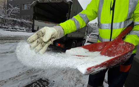 Vehículo esparciendo sal en una carretera nevada