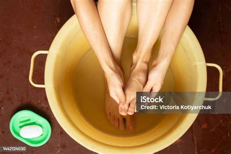 persona sumergiendo los pies en un recipiente con agua