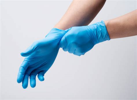Close-up of hands wearing nitrile gloves while painting