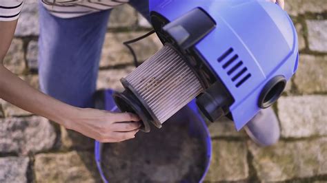 Persona retirando un filtro de una aspiradora Hoover