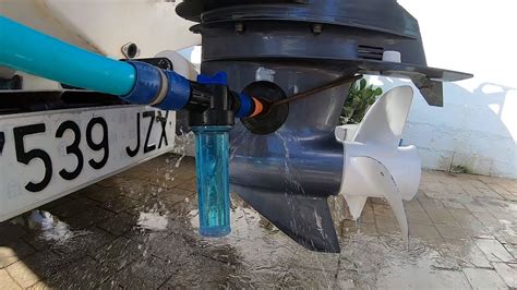 Un motor fueraborda sumergido en un bidón con agua dulce