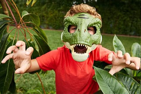 Niño jugando con máscara de Tiranosaurio Rex